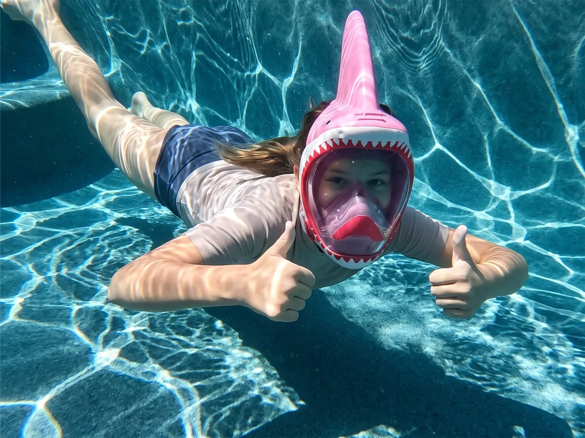 Child underwater giving a thumbs up in a NEBIBO mask